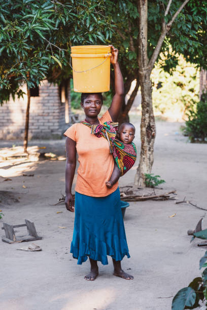 afrykańska matka z synkiem i pojemnikiem na wodę w domu - republic of malawi zdjęcia i obrazy z banku zdjęć