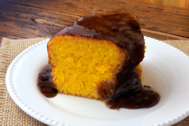 istock slice of carrot cake with chocolate coating on white ceramic plate on rustic wooden table. Closeup 1141639307