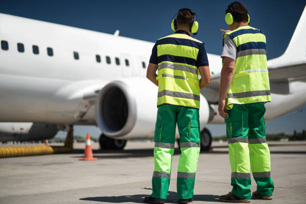 istock Airport workers looking at plane and discussing departure 1141641171