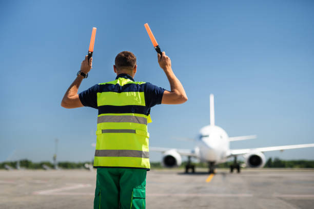 istock Airport worker directing aircraft in right position 1141641180
