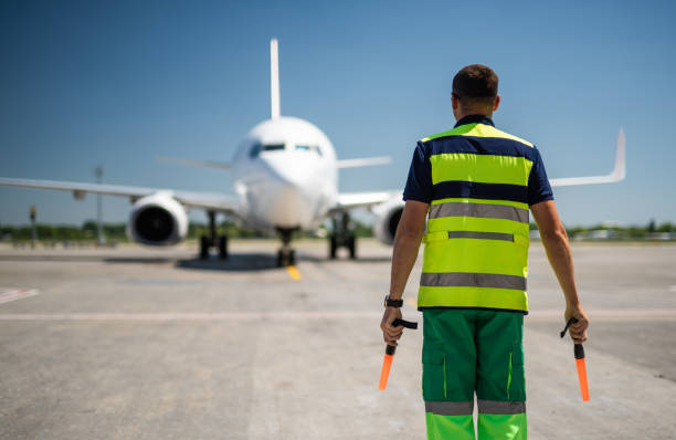 istock Aviation marshaller looking at airplane on runway 1141641196