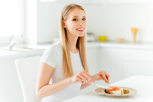 Portrait of attractive youngster millennial have lunch protein dish delicious feel satisfied content glad use fork knife silverware dressed trendy cotton clothing in big pretty kitchen Portrait of attractive youngster millennial have lunch protein dish delicious feel satisfied content glad use fork knife silverware dressed trendy cotton clothing in big pretty kitchen. happy green peas stock pictures, royalty-free photos & images
