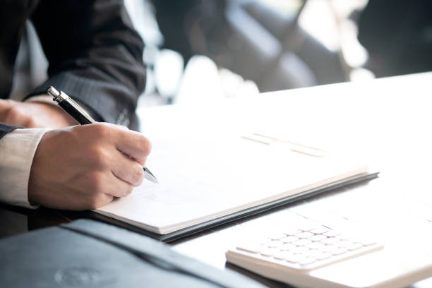 istock Businessman analyzing investment charts and pressing calculator buttons over documents. Accounting Concept. 1141642607