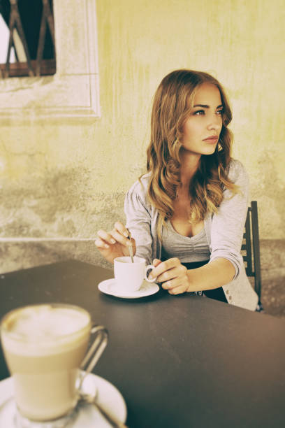 istock Young woman drinking coffee in a sidewalk cafe 1141642905
