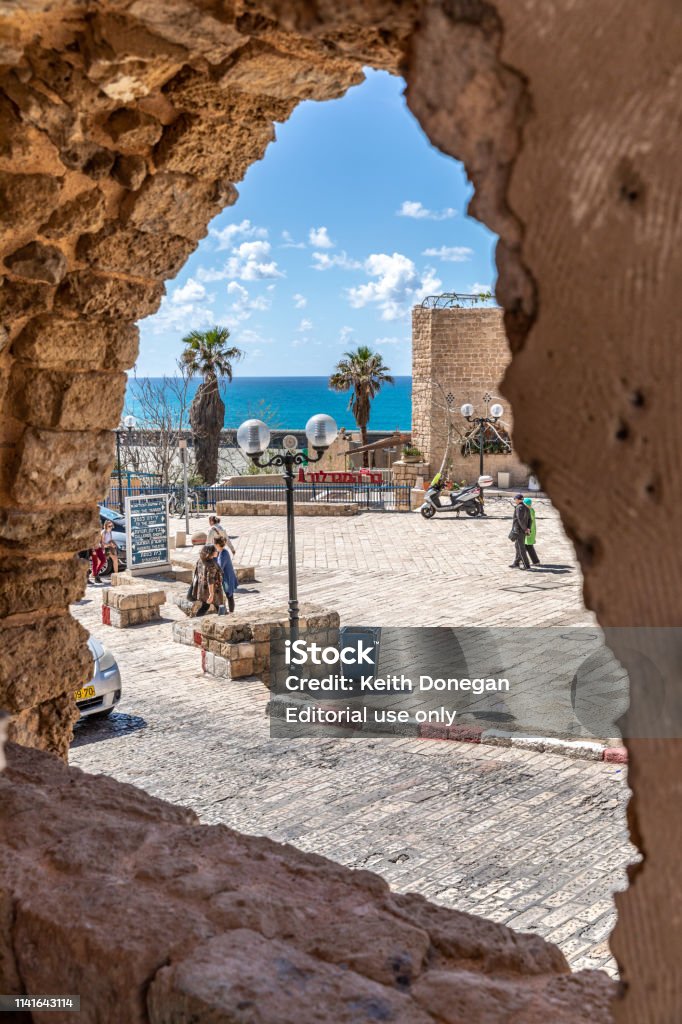 Looking into Old Jaffa City through stone window Jaffa/Israel - Mar 10 2019: Looking into Old Jaffa City through stone window with sea and sky in view Ancient Stock Photo