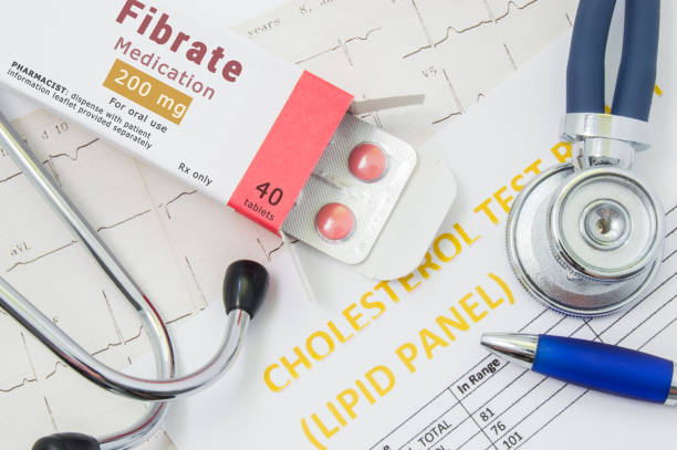 istock Fibrate drug for cholesterol lowering therapy concept photo. Open packaging with medication tablets, on which written 