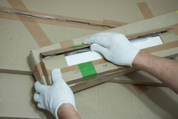 istock Male hands in white gloves with a knife unpack the box. 1141644705