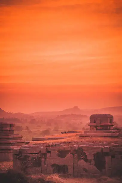 Mistycal and hazy evening view, just minutes after sunset, overlooking the ancient ruins in Hampi, India.