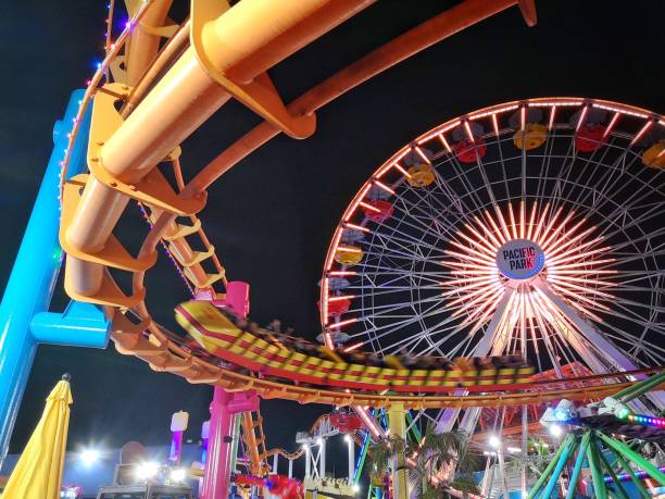 парк развлечений pacific park на пирсе санта-моники с колесом обозрения и горками - santa monica pier santa monica beach night amusement park стоковые фото и изображения