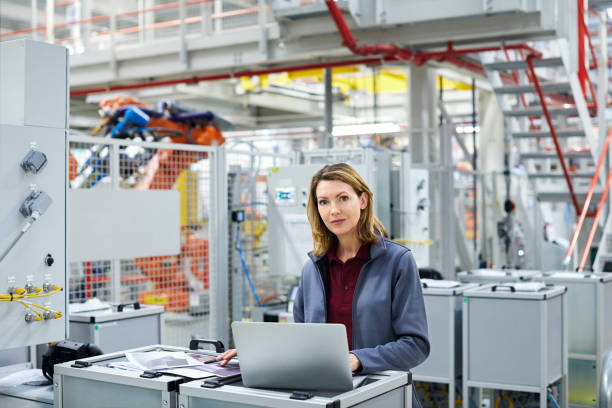 istock Confident engineer with laptop in car plant 1141647806