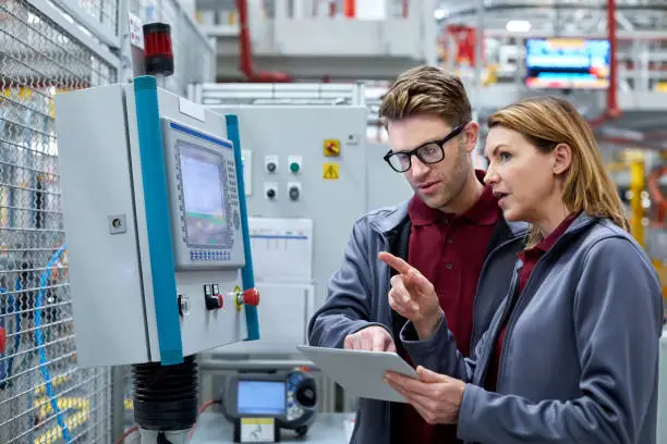 Photo of Car engineers with tablet computer looking away