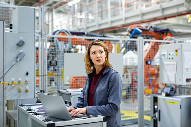 istock Engineer with laptop looking away in car plant 1141648413