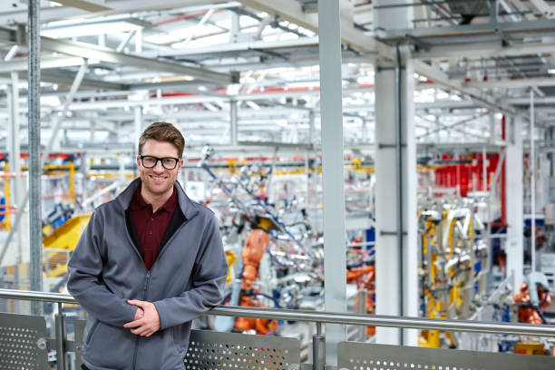 istock Male engineer leaning on railing in car plant 1141648427