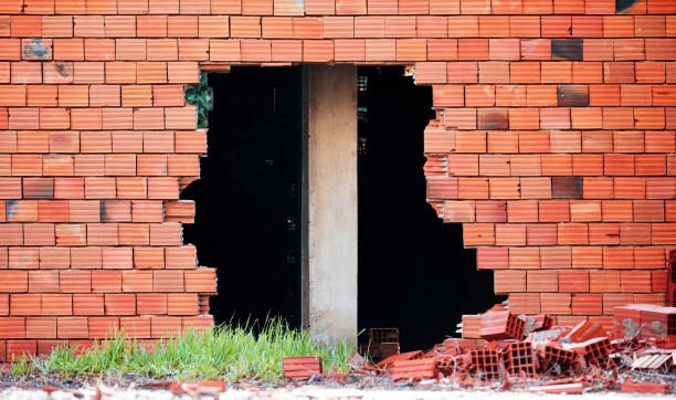 istock Broken red  brick wall with a big hole and a construction column pillar in the middle 1141649777