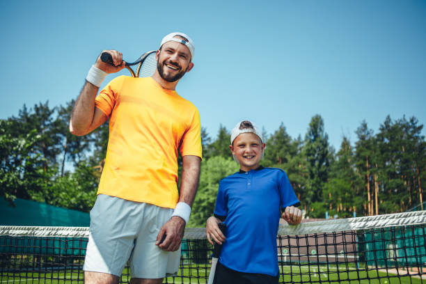 istock Positive man and boy holding tennis rackets 1141650708