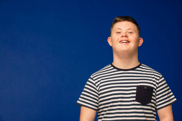 Smiling From Ear to Ear A teenage Down syndrome boy looking at the camera, smiling and looking happy. down syndrome stock pictures, royalty-free photos & images