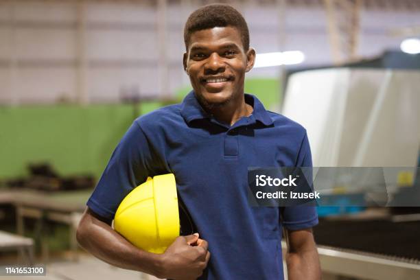 Confident Young Worker In Industry Stock Photo - Download Image Now - Hardhat, Men, T-Shirt