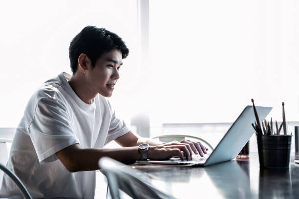 istock Young Asian Man Happily Working In The Office On His Laptop Computer 1141654843