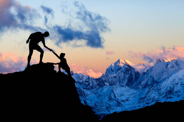 la pareja de trabajo ayudando a la mano, confianza en las montañas - aspirations mountain hiking climbing fotografías e imágenes de stock