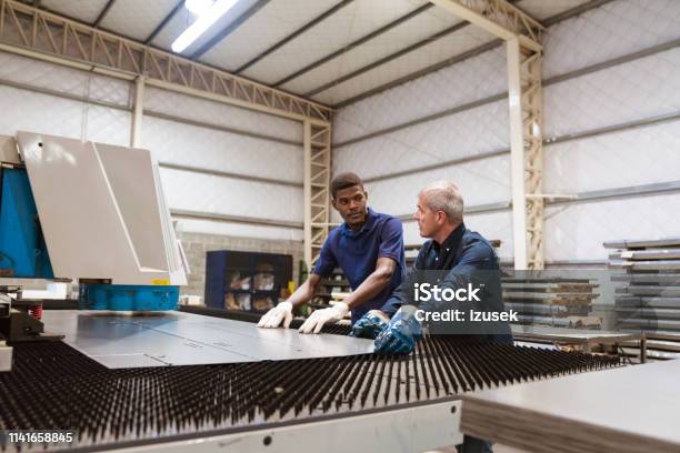 Instructor Teaching Trainee In Factory Stock Photo - Download Image Now - African Ethnicity, Metal, Protective Glove