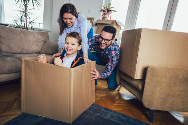 istock Happy family moving home with boxes around, and having fun. 1141660609