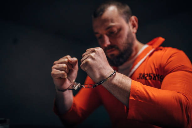 istock Prisoner in orange jumpsuit wearing handcuffs 1141666169