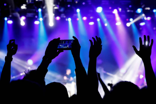 istock Filming a concert on mobile phone camera, stage blue light 1141666314