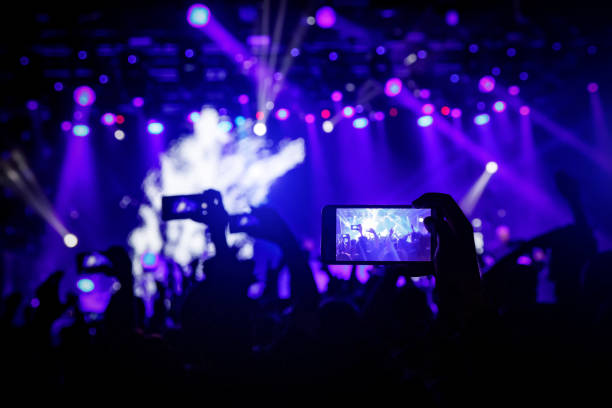 istock Smartphone in hand at a concert, blue light from stage 1141666325