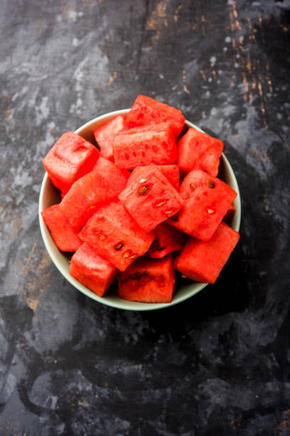 tranches de cubes de fruits melon d’eau/tarbooj servies dans un bol. focus sélectif - healthy eating nature studio shot vertical photos et images de collection