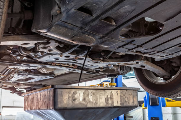 istock Draining engine oil from car lifted on hydraulic lift in workshop during routine service 1141668649