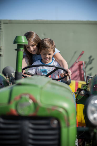 istock Children driving tractor on village 1141669398