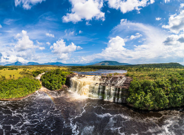 Panoramic Canaima lagoon waterfalls aerial view. Canaima National Park, Venezuela Panoramic Aerial view of Salto El Sapo (Sapo Waterfall) at Canaima National Park Lagoon with group of waterfalls. Afternoon view, La Gran Sabana, Bolivar State, Venezuela. Canaima is a world known place for the beauty of nature and countless waterfalls. Canaima is visited for tourist all around the world looking for adventure and nature encounters. canaima falls stock pictures, royalty-free photos & images
