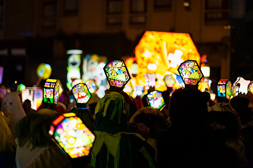 Ruemelinsplatz, Basel, Switzerland - March 11th, 2019. Close-up of a carnival group marching in the old town with their illuminated main and head lanterns.