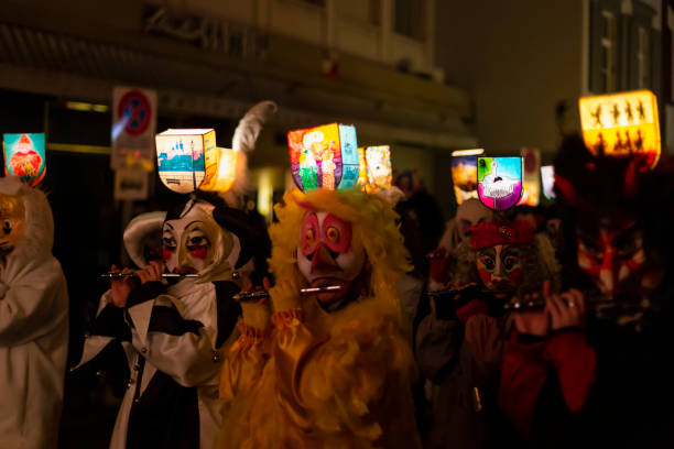 Ruemelinsplatz, Basel, Switzerland - March 11th, 2019. Close-up of piccolo players in their individual carnival costumes with illuminated head lanterns.