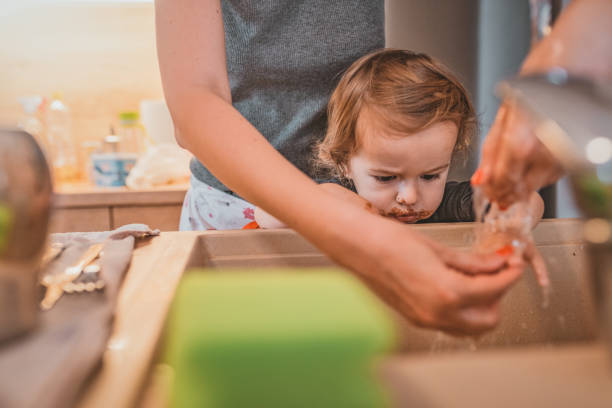istock Mother helping son to wash hands after baking 1141671584