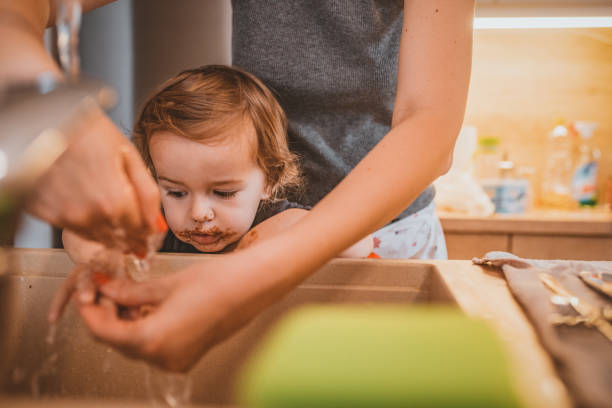istock Son washing hands with mother in the sink 1141672872