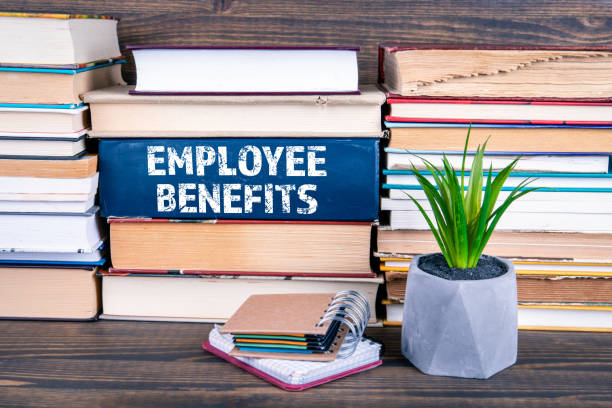 istock Employee Benefits concept. Books stacked on table 1141673229