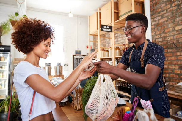 cliente que paga comprando na verificação geral da mercearia livre plástica sustentável - groceries women bag customer - fotografias e filmes do acervo