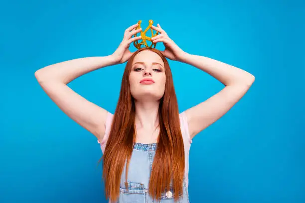 Close up photo beautiful amazing she her lady self coronation process headwear head glossy yellow gold crown presenting special status wear casual jeans denim overalls clothes isolated blue background.