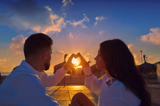 istock Couple young in beach vacation sunrise 1141678250
