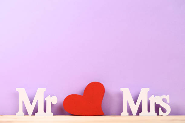 istock White letters Mr and Mrs with red heart on purple background 1141678266