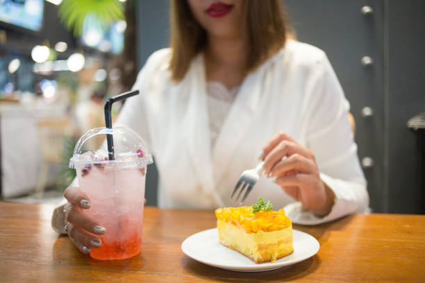 istock Young Asian Businesswoman Eating Mango Cake 1141678469