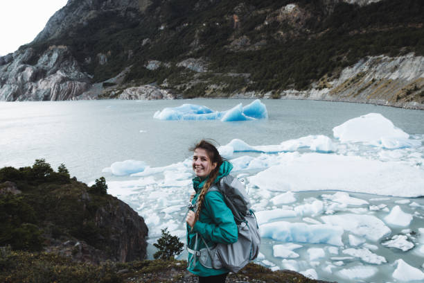 Woman backpacker e joying the view of icebergs, glacier and mountains at Torres Del Paine Woman with backpack hiking to glacier Grey in Torres Del Paine National Park in Patagonia, Chile chile tourist stock pictures, royalty-free photos & images