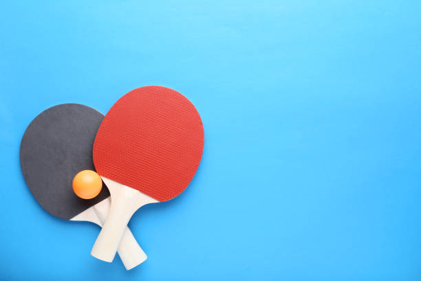 istock Table tennis rackets with ball on blue background 1141679696