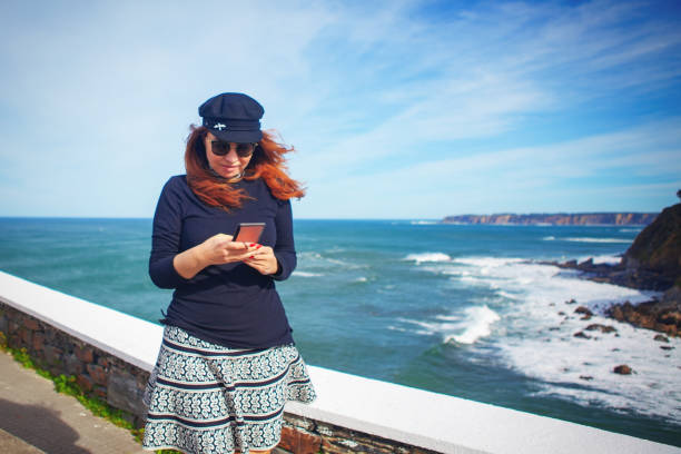 Woman using smart phone near the sea