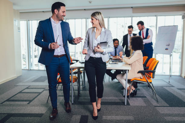 istock Portrait of two young businesspeople using digital tablet while colleague in background. 1141680406