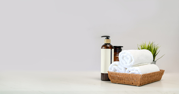 Towels in basket and spa accessory on Mable table