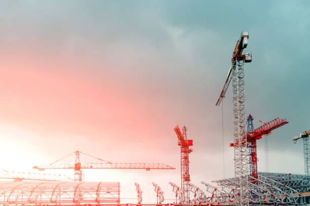 istock Construction site. Big industrial tower cranes with unfinished high raised buildings and blue sky in background. Scaffold. Modern civil engineering. Contemporary urban landscape. 1141681740