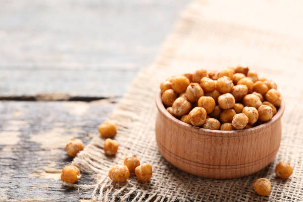 Roasted chickpeas in bowl on gray wooden table stock photo