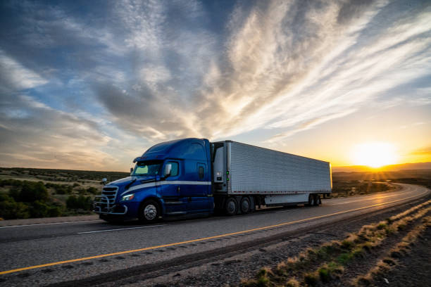 Lone truck with semi-trailer at sunset on a desert highway